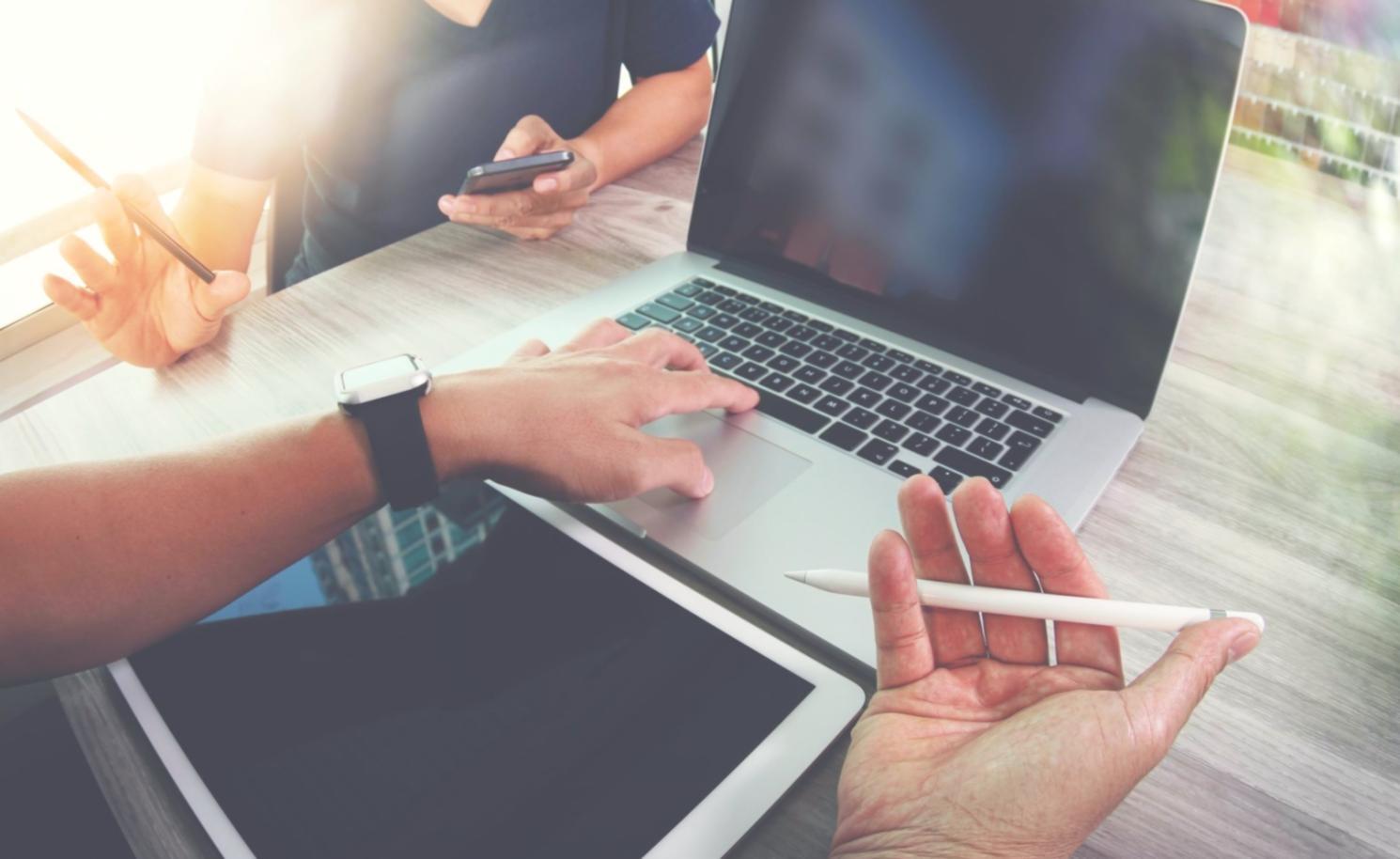 Gruppe von Entwicklern diskutiert gemeinsam am Whiteboard